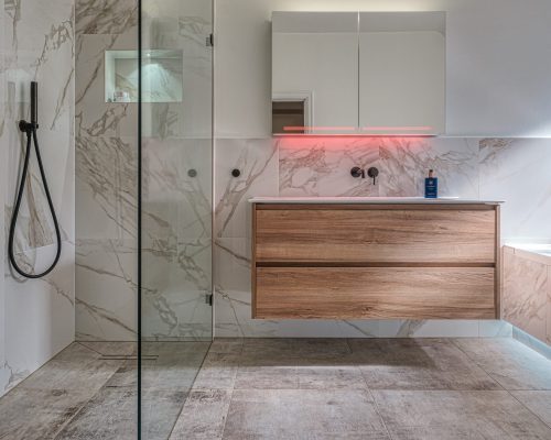 Modern family bathroom in Hampton with marble tiles and wooden vanity unit